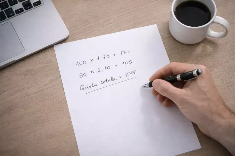 Persona con penna e foglio che calcola le vincite delle scommesse